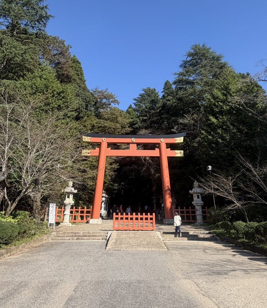 青空の下、森に囲まれた香取神宮の朱色の大鳥居